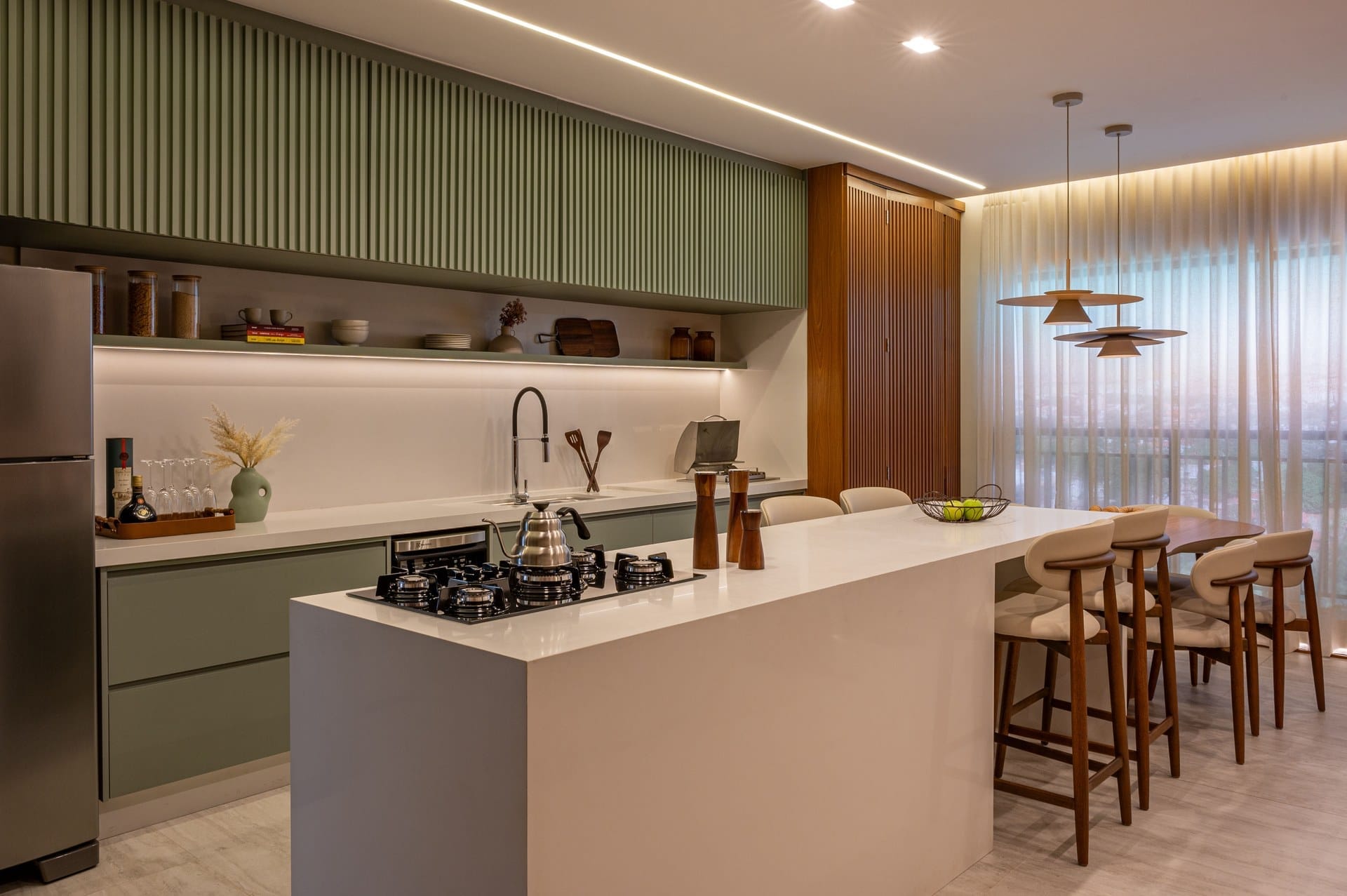 Cozinha do apartamento decorado com ilha e integração à sala de jantar